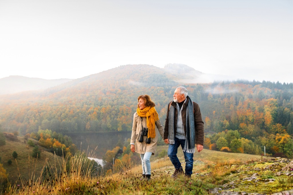 Couple walking through mountains holding hands